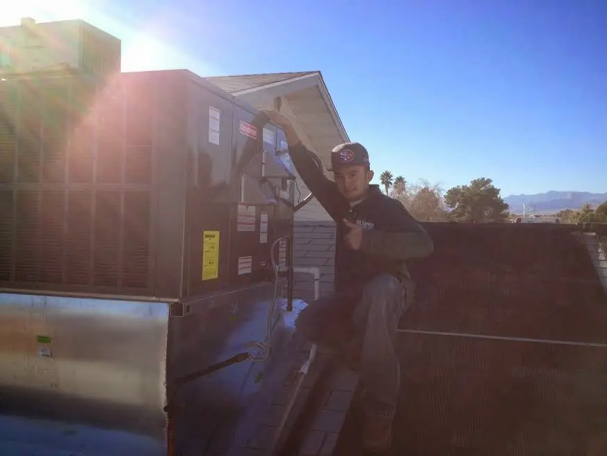 HVAC technician performing Boiler Repair on a rooftop unit in Burlington